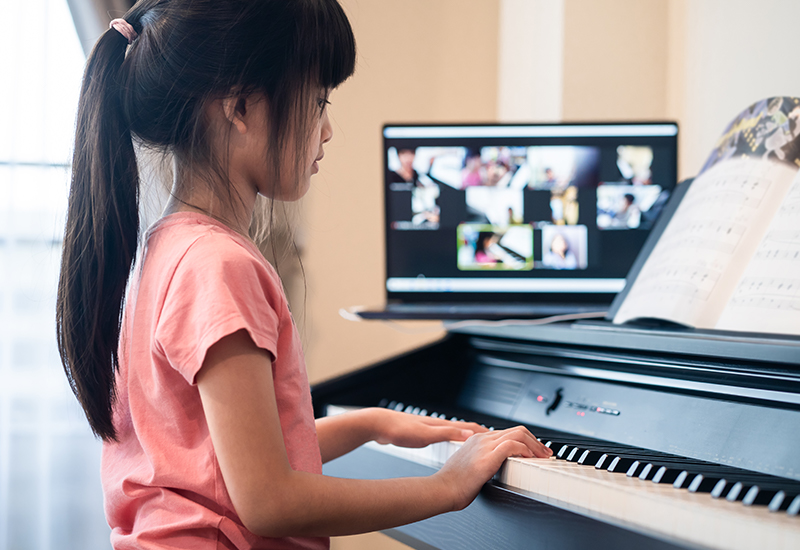 student playing the piano during an online piano lesson